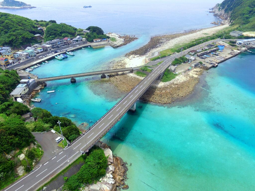 【柏島 がっかり】柏島の空撮写真 エメラルドグリーンの海と集落を結ぶ橋と船が行き交う港の風景