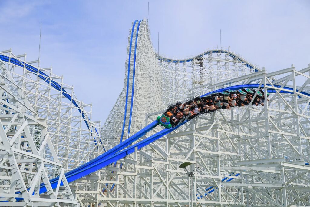 【ナガシマスパーランド混雑予想】たくさんの人が乗ったジェットコースター白鯨が白い骨組みの中を青いレールに沿って走る様子