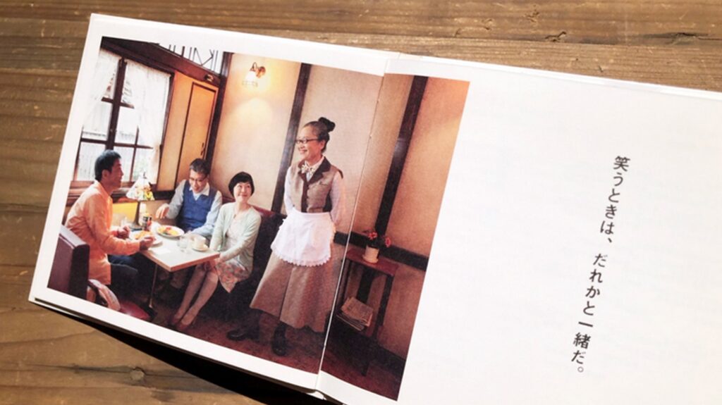 【パンとスープとネコ日和ロケ地】テーブルで食事をする家族と給仕をする女性のいる喫茶店の写真