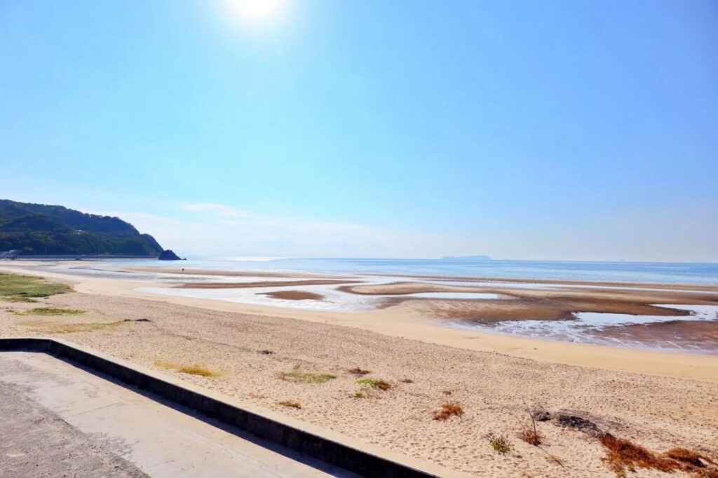 【Chichibugahama Beach】A sandy beach with shallow tidal flats under a clear blue sky.