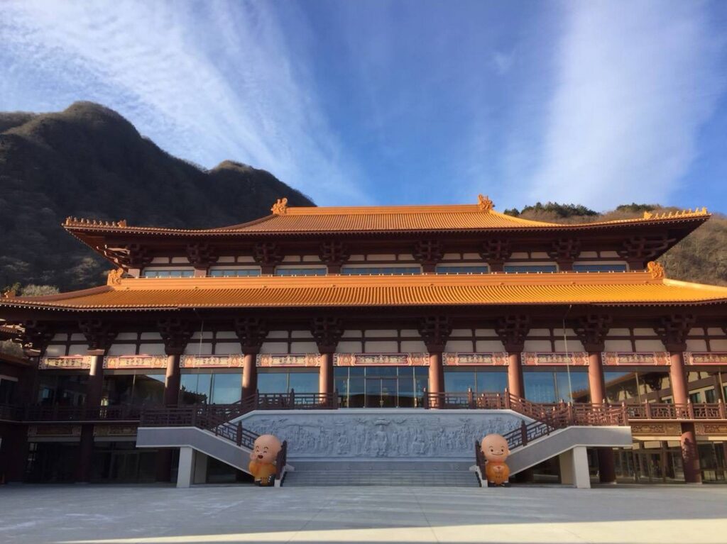 【法水寺キングダムロケ地】オレンジ色の屋根の寺院と、左右に置かれた笑う石像