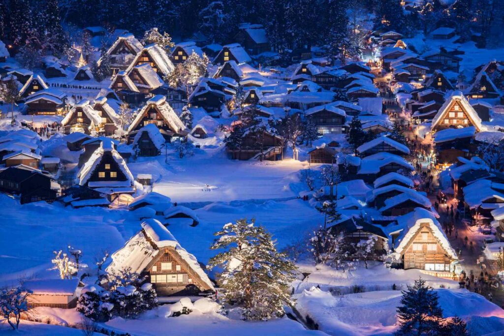 【Shirakawa-go】snow-covered traditional Japanese village at night with lit up Gassho-zukuri houses
